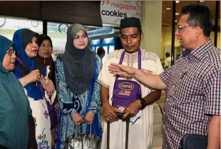  ??  ?? Have a good trip: Ahmad Razif (right) having a chat with Muhammad Ramadhan and his family members at the Sultan Mahmud Airport in Kuala Terengganu.