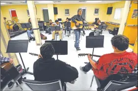 ?? NWA Democrat-Gazette/J.T. WAMPLER ?? David Singleton, guitar teacher at the Arkansas Arts Academy, plays Thursday along with his students in Rogers. The charter school is making changes in preparatio­n for next school year, including replacing about 20 percent of its staff. For photo...