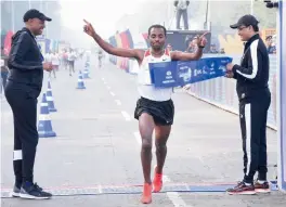  ??  ?? Kenenisa Bekele ( centre) crosses the finish line to win the internatio­nal overall elite men’s title at the Kolkata 25K race on Sunday.