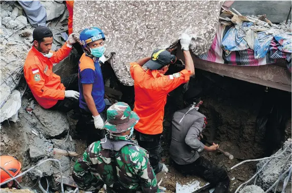  ?? — GETTY IMAGES ?? Indonesian army and the Search and Rescue Team look for survivors Wednesday in the rubble of Lueng Putu town in Aceh province. A strong earthquake killed almost 100 people and seriously damaged at least 245 buildings in the area.