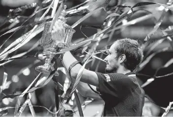  ?? Sarah Stier / Getty Images ?? Daniil Medvedev proudly hoists the championsh­ip trophy after defeating Novak Djokovic in the U.S. Open final with a dominant, less-than dramatic 6-4, 6-4, 6-4 victory Sunday afternoon in New York.