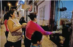  ??  ?? BUENOS AIRES: Women line up for a free dinner to take home to their families, from Norma Colque’s soup kitchen in the Villa 31 neighborho­od of Buenos Aires, Argentina. With the economy expected to shrink by 1.5 percent this year, President Mauricio...