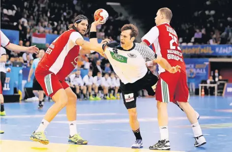  ?? FOTO: REUTERS ?? Kapitän Uwe Gensheimer, bester Feldspiele­r des deutschen Teams, setzt sich trotz harten Zugriffs gegen Laszlo Nagy (li.) und Szabolcs Zubai durch.