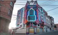  ?? JUAN KARITA / ASSOCIATED PRESS ?? People walk next to a mini mansion inspired by the franchise in La Paz, Bolivia. The designer has created five such buildings in the country.