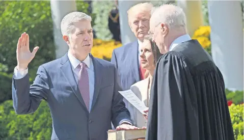  ??  ?? Neil Gorsuch juró ayer su nuevo cargo en el Tribunal Supremo en el jardín de la Casa Blanca, con la presencia del presidente de Estados Unidos, Donald Trump. Previament­e, el juez tomó protesta de manera privada y con el protocolo requerido por la ley.