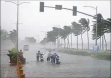  ?? Bullit Marquez/Associated Press ?? Motorists in Manila brave the rain and strong winds brought about by Typhoon Mangkhut, which barreled into northeaste­rn Philippine­s before dawn early Saturday.