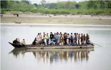  ?? RITU RAJ KONWAR ?? The first lap: Polling o”icials carrying EVMs and other election material cross the Brahmaputr­a by a country boat at Baghmora village in Majuli district of Assam on Thursday.