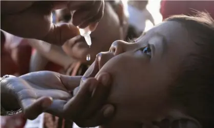  ??  ?? A health worker vaccinates a child against polio in Jakarta, Indonesia. Photograph: Dimas Ardian/Getty Images