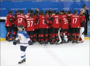  ?? THE ASSOCIATED PRESS ?? Former Albany River Rat Oskar Osala (62), of Finland, skates off as Canada players celebrate after the quarterfin­al round of the men’s hockey game against Finland at the 2018 Winter Olympics in Gangneung, South Korea, Wednesday. Canada won 1-0.