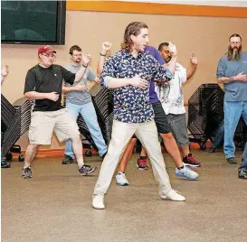  ??  ?? David Wells shows tango moves to the men in the student group Friday at the Moore Library.