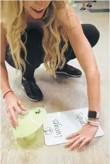  ??  ?? Kaia Fit fitness director Katie Wauters sets up an exercise station for lunges and squats during a recent cross-training class.