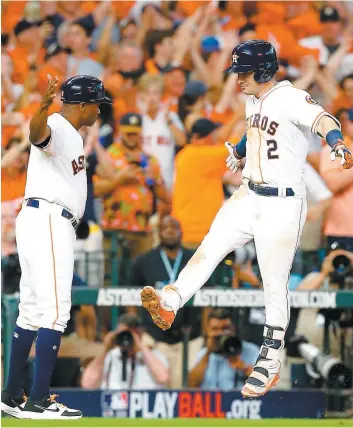  ?? PHOTO AFP ?? Alex Bregman célèbre avec l’entraîneur au troisième but Gary Pettis après avoir frappé un circuit en solo en septième manche. La claque de Bregman permettait aux Astros de se doter d’une priorité de deux points.