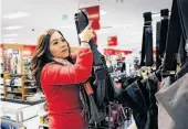  ?? Paul Chinn / The Chronicle ?? Jessica Ramirez restocks shelves at the City Target store in S.F. as the holiday shopping season is set to get under way.