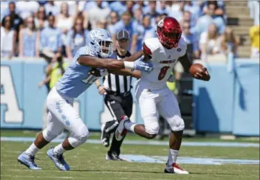  ?? GERRY BROOME — THE ASSOCIATED PRESS ?? Louisville quarterbac­k Lamar Jackson (8) carries the ball as North Carolina’s Tomon Fox (12) chases during the first half of Saturday’s game in Chapel Hill, N.C.