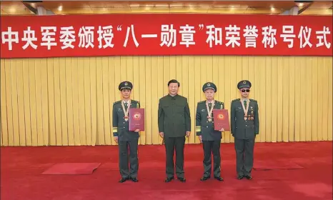  ?? LI GANG / XINHUA ?? President Xi Jinping, who is also general secretary of the Communist Party of China Central Committee and chairman of the Central Military Commission, poses for a group photo on Wednesday with August 1 Medal recipients Nie Haisheng (left), Qian Qihu (second right) and Du Fuguo (right) at the award ceremony in Beijing.