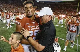  ?? STEPHEN SPILLMAN / FOR AMERICAN-STATESMAN ?? Chris Warren III gets congratula­tions from Texas coach Tom Herman after scoring the winning TD in Saturday’s 2OT victory.