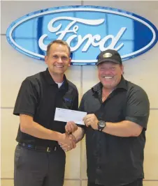  ??  ?? Shaun Airey, Moose Jaw Ford Manager presents a cheque to Aaron Ruston representi­ng the15 Wing Fellowship at the dealership on July 17th.