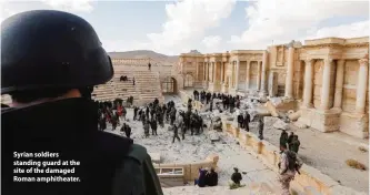  ??  ?? Syrian soldiers standing guard at the site of the damaged Roman amphitheat­er. 'A few scratches'