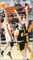  ?? Westside Eagle Observer/MIKE ECKELS ?? Facing a wall of Tiger defenders, Johnny Dunfee (left) goes up for a jumper from inside the lane during the Gravette-Prairie Grove conference basketball game in Gravette on Friday night. Dunfee made the shot, which accounted for two of his seven points in the contest.