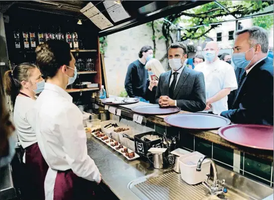  ?? LIONEL BONAVENTUR­E / AFP ?? El president francès, Emmanuel Macron, parlant ahir amb el personal d’un restaurant en la seva visita a Saint-Cirq-Lapopie