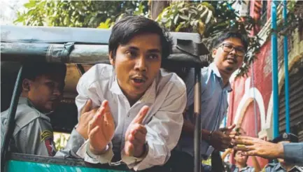 ?? Ye Aung Thu, AFP ?? Detained journalist­s Kyaw Soe Oo, center, and Wa Lone, right, are taken from court in handcuffs after being denied bail Wednesday in Yangon, Myanmar. The two Reuters reporters face 14 years in jail under a secrecy act.
