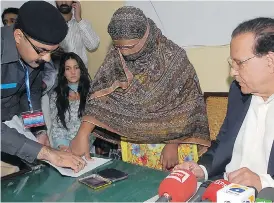  ?? AFP PHOTO / DIRECTORAT­E GENERAL PUBLIC RELATIONS (DGPR) PUNJAB / GETTY IMAGES ?? Asia Bibi, shown here in November 2010, applies her thumbprint to appeal papers filed against her death sentence for blasphemy.