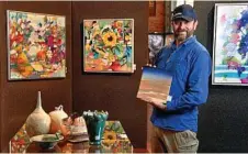  ??  ?? Downlands Art Exhibition curator Evan Hollis holds a Lindsay Muir piece surrounded by works of feature artist Diana Battle.