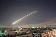  ?? AMMAR/AP HASSAN ?? The Damascus sky lights up with anti-aircraft fire early Saturday as the U.S. launches an attack on Syria. Officials , said the targets were a scientific research center, a chemical weapons storage facility and a storage facility and command post . .