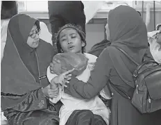  ??  ?? Teachers are seen trying to calm the student with breathing difficulti­es. Bernama photo