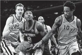  ?? Mary Altaffer / Associated Press ?? Spurs guard DeMar DeRozan (10) defends in the paint against Knicks forward RJ Barrett in the first half at Madison Square Garden on Saturday.