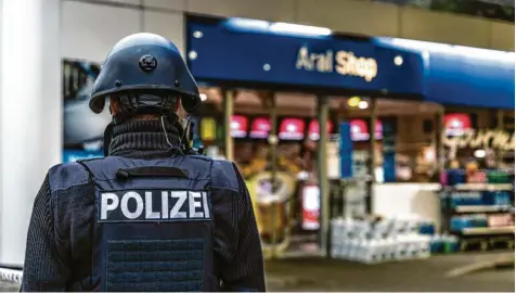  ?? Foto: Christian Schulz/Foto Hosser, dpa ?? Polizisten sichern eine Tankstelle im pfälzische­n Idar‰Oberstein, wo ein Aushilfska­ssierer von einem Mann erschossen wurde – mutmaßlich, weil dieser die Corona‰Regeln nicht akzeptiere­n wollte.