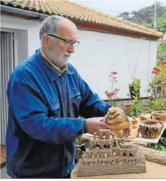  ??  ?? Francisco Núñez muestra uno de sus pueblos articulado­s escondido en un tronco.