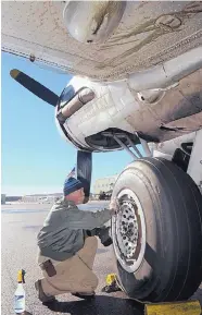  ?? JIM THOMPSON/JOURNAL ?? Crew Chief Paul Workman cleans the landing gear of the B-17 Flying Fortress Aluminum Overcast at Double Eagle II Airport on Friday. The World War II-era bomber will be at the airport through Sunday. Flights and ground tours are available. For more...