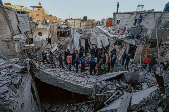  ?? AHMAD HASABALLAH/GETTY IMAGES ?? Residents inspected the remains of their homes in Rafah Monday after an Israeli bombardmen­t and raid. Some Gazan families (left) decided to flee the region once more.