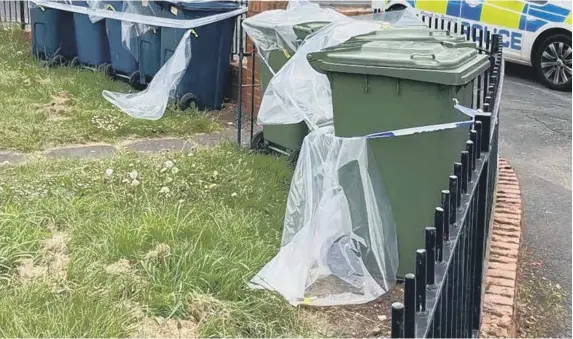  ??  ?? The waste bins with plastic and police tape around them.