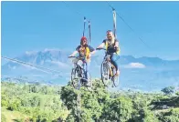  ??  ?? SERONOK: Dua lagi pengunjung tidak gayat menunggang basikal Sky Bike berlatarbe­lakangkan Gunung Kinabalu.