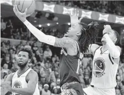  ?? BRANDON DILL AP ?? Grizzlies guard Ja Morant, who made 15 of 31 shots, shoots between Warriors guard Jordan Poole (right) and forward Andrew Wiggins.