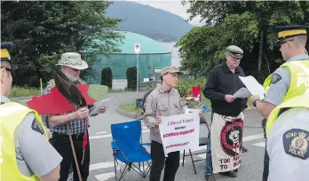  ?? DAVIDCAREY ?? An RCMP officer reads an injunction to anti-pipeline protesters in Burnaby last week. A B.C. Supreme Court judge has scrapped a 10-minute warning police were required to read before arrests could be made.