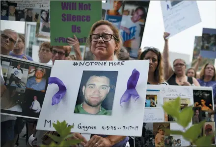  ?? JESSICA HILL — THE ASSOCIATED PRESS FILE ?? In this file photo, Christine Gagnon, of Southingto­n, Conn., holds a sign during a protest with others who have lost loved ones to OxyContin and opioid overdoses, outside the Purdue Pharma headquarte­rs in Stamford, Conn.