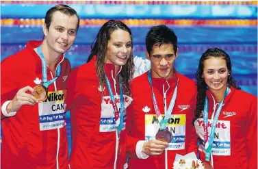  ?? — AP ?? Canada’s Yuri Kisil, left, Penny Oleksiak, Richard Funk and Kylie Masse show off the bronze medals they won in the 4x100-metre mixed medley relay on Wednesday at the world swimming championsh­ips in Budapest, Hungary.