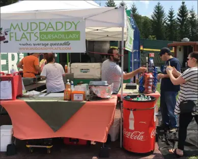  ?? MICHAEL GWIZDALA - MEDIANEWS GROUP ?? People get food from Muddaddy Flats during the first-ever Food Truck Festival at Joseph L. Bruno Stadium Saturday afternoon.