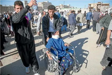  ?? PHOTOS: REUTERS ?? Men tend to an injured woman in the Iranian city of Sarpol-e Zahab following the 7.3-magnitude earthquake that hit the Iran-Iraq border region.