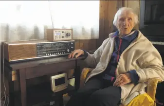  ?? Mark Lewis / Associated Press ?? Judith Haaland, 98, sits next to her decades-old radio set in Stavanger, Norway. Now blind and living alone, her radio has been her tether to the outside world.