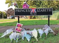  ?? Picture: Mikal Ludlow Photograph­y ?? Flowers and a picture of Queen Elizabeth II are left beside the sign to Princess Elizabeth Way in Cheltenham, Gloucester­shire. As a young princess she gave her name to the route and planted an oak tree there in 1951 when it was completed