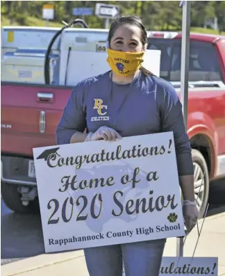  ?? BY HOLLY JENKINS ?? RCHS Athletic Director Courtney Atkins hands out yard signs to the seniors at a drive-thru event last week.