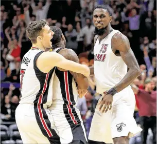  ?? MIKE EHRMANN / GETTY IMAGES ?? Dion Waiters gets congratula­ted by Goran Dragic (7) and Okaro White after hitting the winning shot in his 33-point performanc­e during the Heat’s victory over the Warriors.