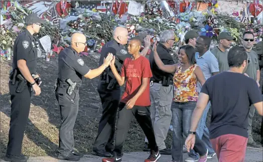  ??  ?? Students are greeted by law enforcemen­t as they head back to school at Marjory Stoneman Douglas High School on Wednesday in Parkland, Fla. With a heavy police presence, classes resumed for the first time since 17 students and teachers were killed by a...