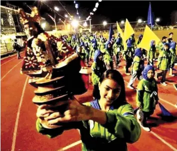  ?? FACEBOOK OF RICKY BALLESTERO­S PHOTOS FROM THE ?? Cebuana athlete turned beauty queen Beatrice Luigi Gomez holds the image of Sto. Niño as muse and volleyball player of the Visayas contingent at the 2010 Milo Little Olympics National Finals held in Cagayan de Oro City. The other photo shows Gomez in action at the Visayas eliminatio­n of the 2013 Nestea Beach Volley National Championsh­ips in Moalboal, Cebu.