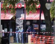  ?? JOHN RAOUX — THE ASSOCIATED PRESS ?? A police officer walks by the front of a Chicago Pizza and GLHF Game Bar on Monday at the scene of fatal shooting on Sunday at The Jacksonvil­le Landing in Jacksonvil­le, Fla.