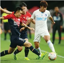  ?? — AFP photo ?? Dalian Pro’s Li Shuai (right) competes for the ball with Shenzhen FC’s Ge Zhen (left) and Li Yuanyi during their Chinese Super League match in Dalian, in China’s northeast Liaoning province.